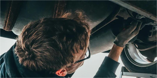 An engineer is using a fantik tool to repair a broken-down vehicle