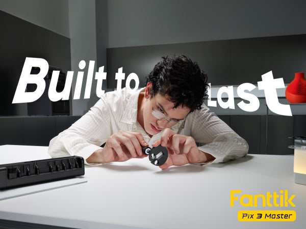 In the image, a man is using a Fanttik Pix 3 Master Electric Detail Sander to sand a small black 3D object on a white table. The background features the words "Durable" in large print, and there is a small yellow "Pix 3 Master" model mark in the lower right corner.
