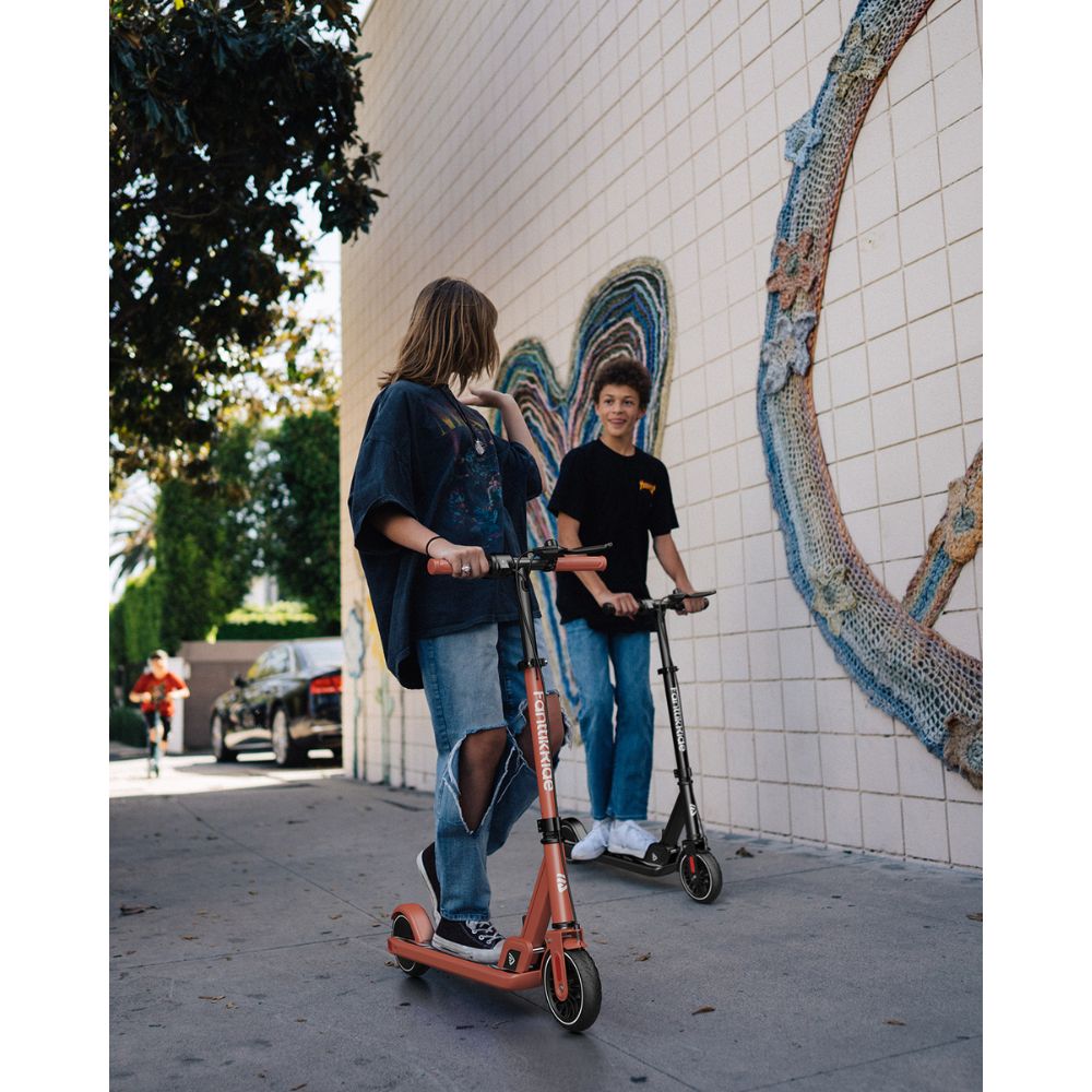 Teenagers riding FanttikRide T9 Electric Scooters, antique red and black, on a sidewalk with wall art