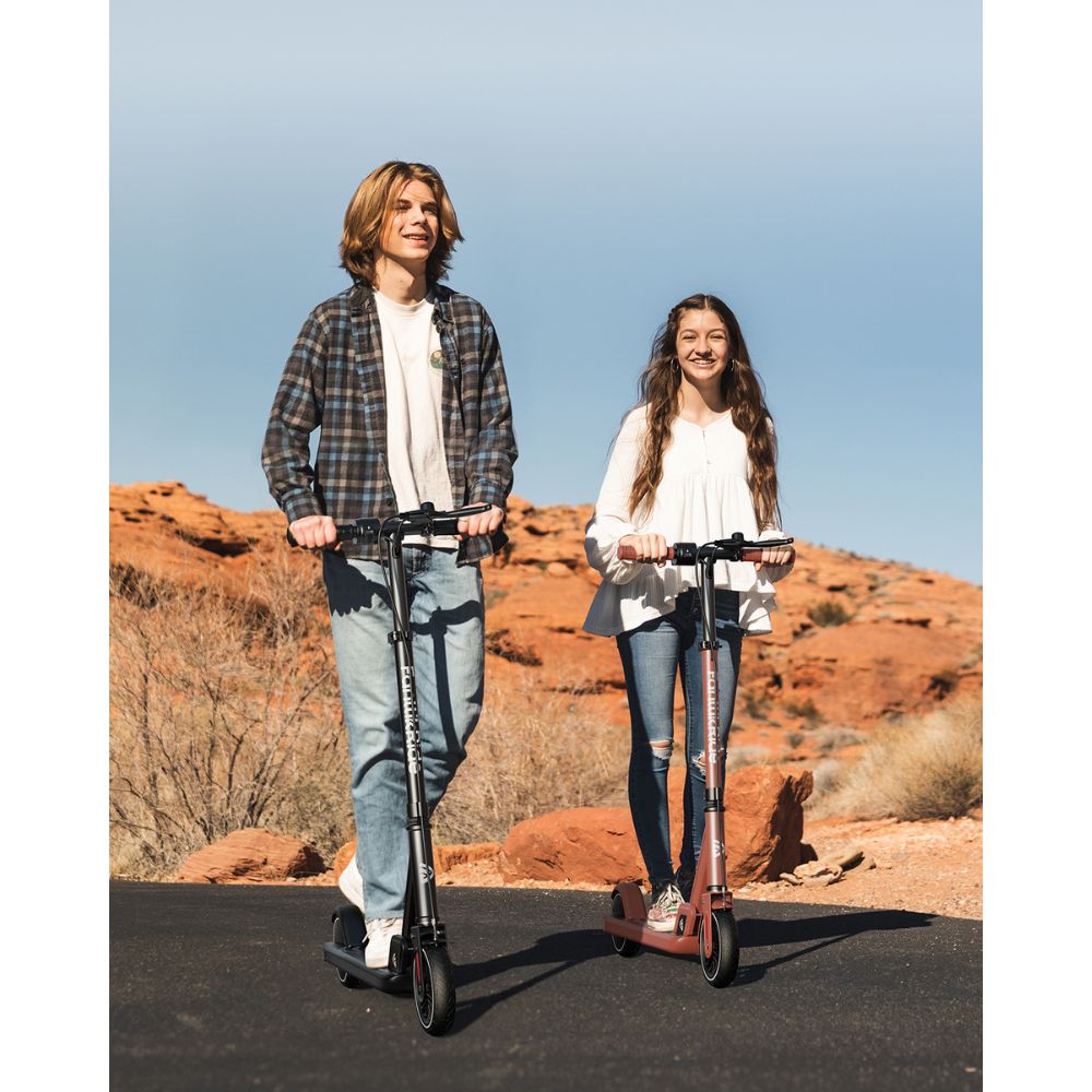 Two teenagers riding FanttikRide T9 Electric Scooters on a scenic outdoor path, shown in black and red models, ideal for teens.