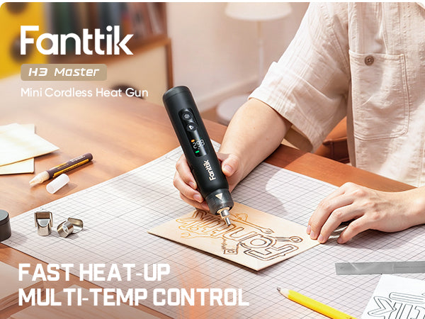 A person using a Fanttik H3 Master Mini Cordless Heat Gun on a piece of wood at a wooden desk, with product text overlays.