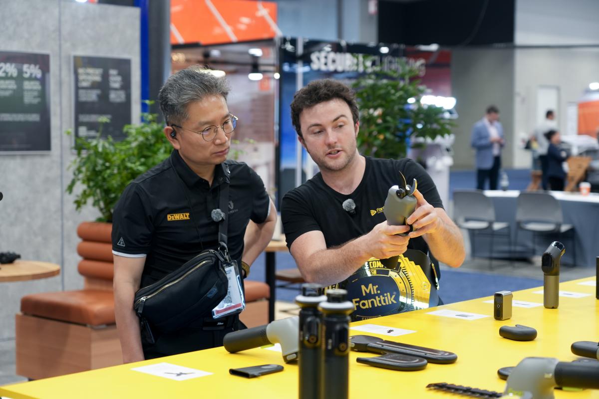 Two men at a table with electronic devices in an indoor setting