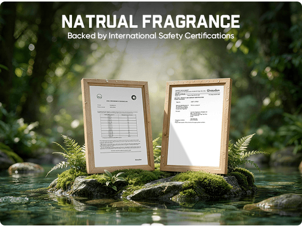 Two framed fragrance certification documents displayed on mossy rocks in a forest stream, with large text at the top reading 'NATURAL FRAGRANCE' and 'Backed by International Safety Certifications'.
