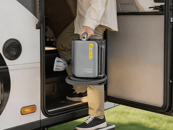 Person using a Fanttik Textra 11 Apex Cordless Carpet and Upholstery Cleaner inside a vehicle