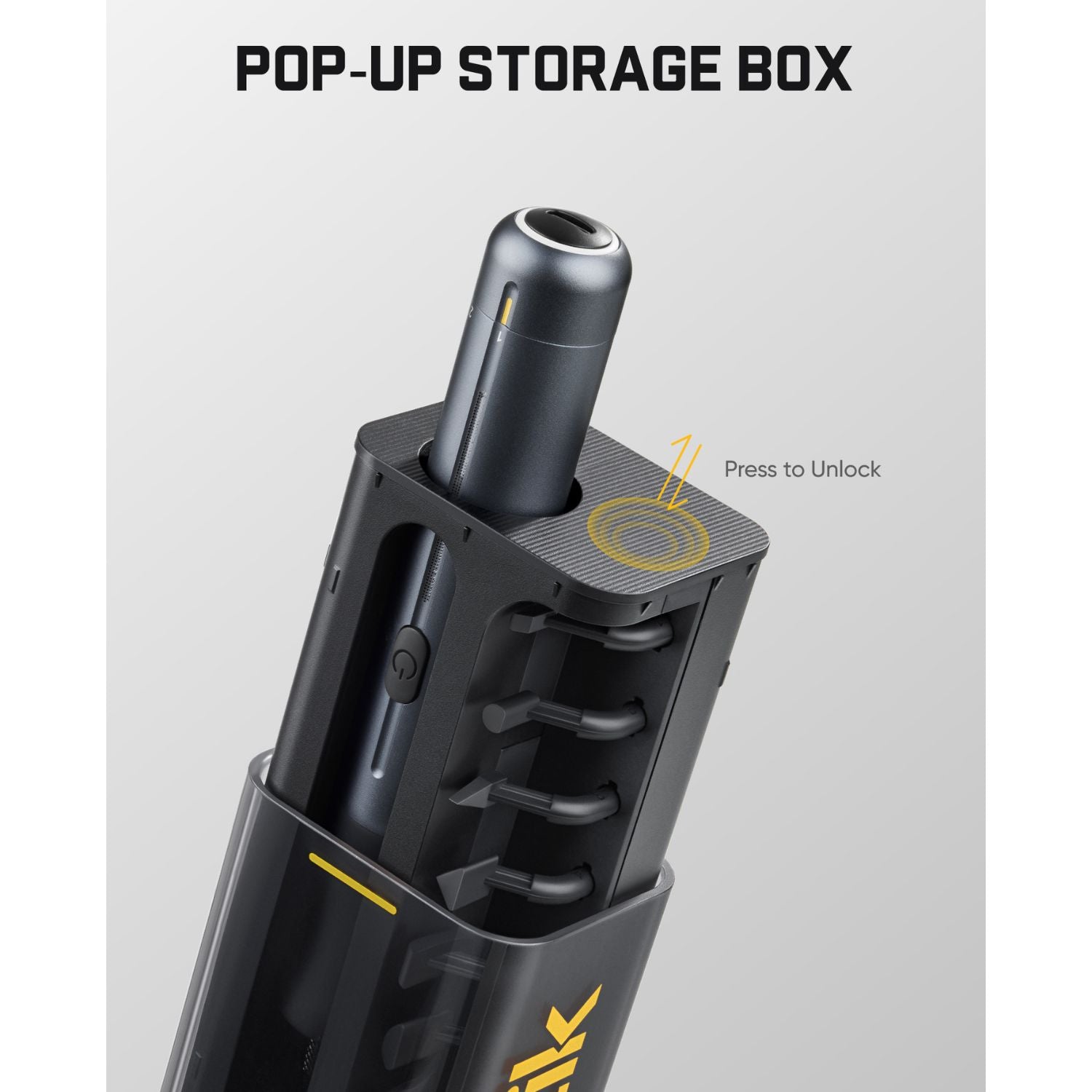 A black pop-up storage box shown on a light gray background with the text 'POP-UP STORAGE BOX' at the top and a yellow callout reading 'Press to Unlock.' The box is partially open, revealing a cylindrical insert or accessory inside.