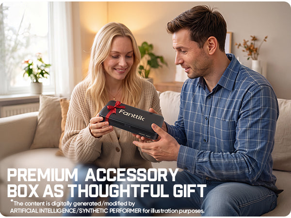 A man and a woman sitting on a beige sofa in a living room setting, looking at a black gift box with a red ribbon and the brand name 'Fanttik' visible on the front. White text on the left reads 'PREMIUM ACCESSORY BOX AS THOUGHTFUL GIFT'.