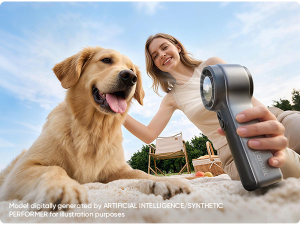 Woman holding a GoFlow 11 Apex Handheld Fan next to a dog outdoors with a clear sky.