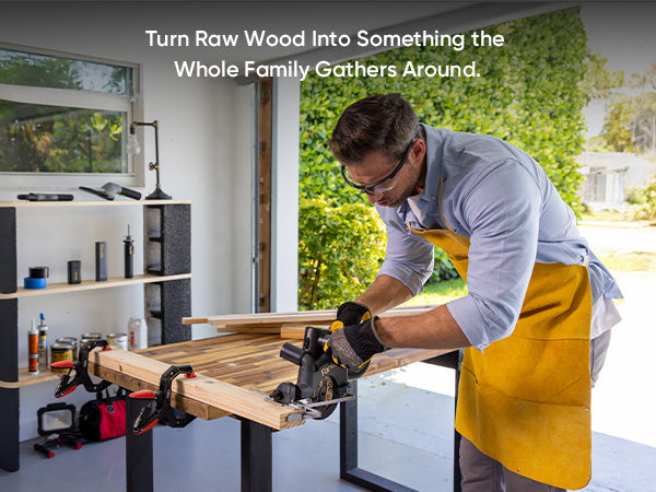A man wearing safety glasses, a light blue shirt, and a yellow apron uses a circular saw to cut a piece of raw wood on a workbench inside a garage. A text overlay at the top reads, 'Turn Raw Wood Into Something the Whole Family Gathers Around.